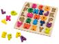 Dřevěné puzzle s barevnými písmeny abecedy, některá mimo desku.