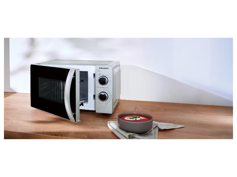 Mikrovlnná trouba Silvercrest s otevřenými dvířky a miska polévky na dřevěném stole.