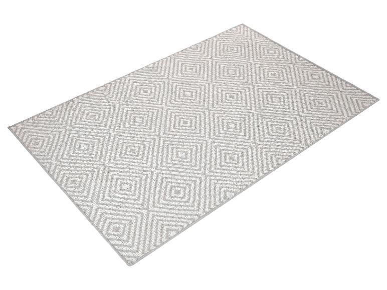 Světle šedý koberec s geometrickým vzorem.