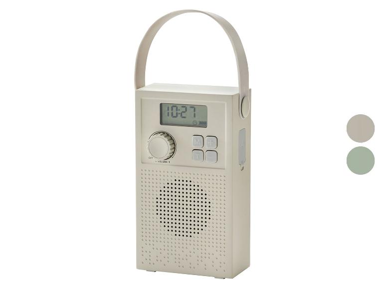 Přenosné rádio s digitálním displejem zobrazujícím 10:27 a rukojetí, v béžové barvě.