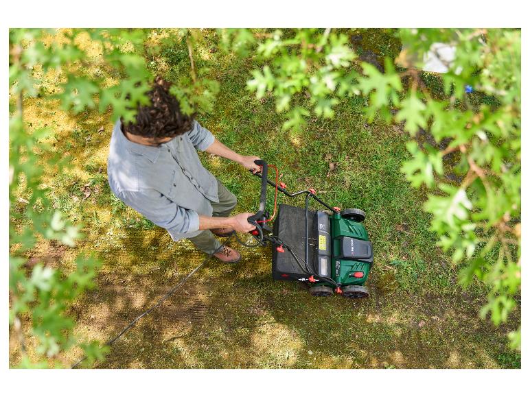 Muž seče trávu elektrickou sekačkou Parkside.
