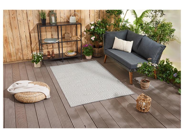 Šedý venkovní koberec s geometrickým vzorem, zahradní nábytek a doplňky.