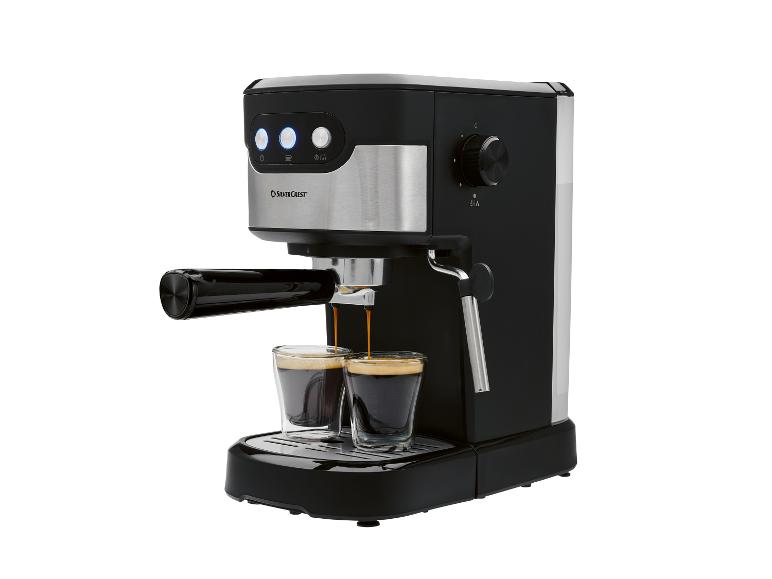 Černý a stříbrný kávovar na espresso nalévající kávu do dvou malých sklenic.