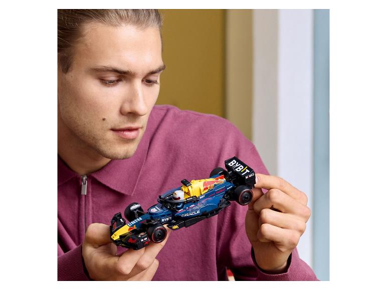 Muž drží v rukou Lego Red Bull Racing formuli 1.