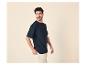 Muž v tmavě modrém tričku a béžových kalhotách, dívající se do strany.