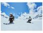 Dvě osoby provozující zimní sporty na sněhu, jedna na lyžích a druhá na snowboardu.