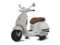 Bílý skútr Vespa s hnědým sedadlem.