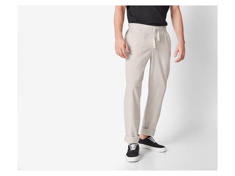 Béžové lněné kalhoty a černé tenisky: ležérní styl.