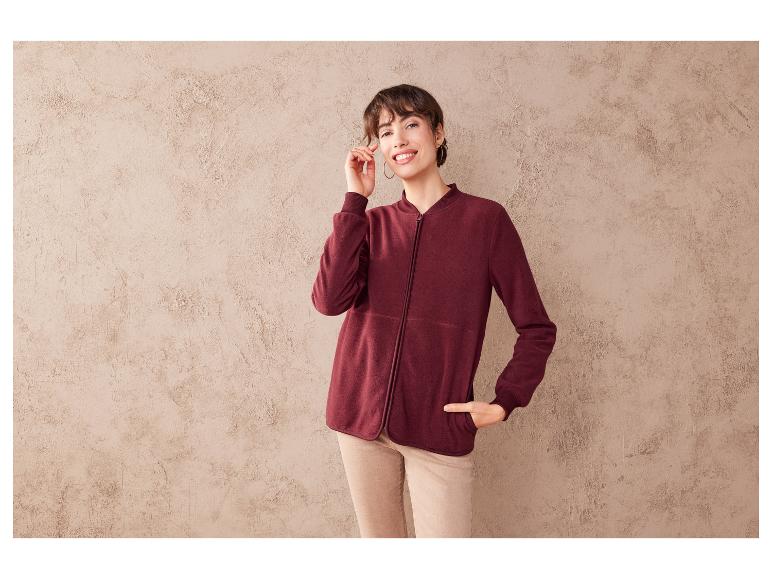 Žena v bordové fleecové bundě se zipem.