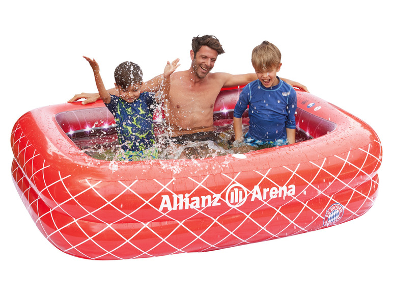 Dospělý a dvě děti si hrají v nafukovacím bazénu Allianz Arena.