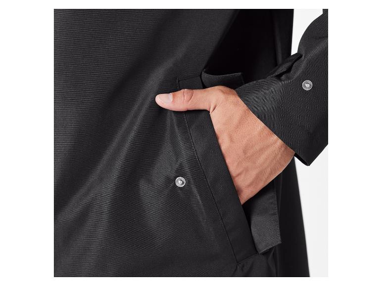 Detailní záběr na černou bundu s kapsou a knoflíkem.
