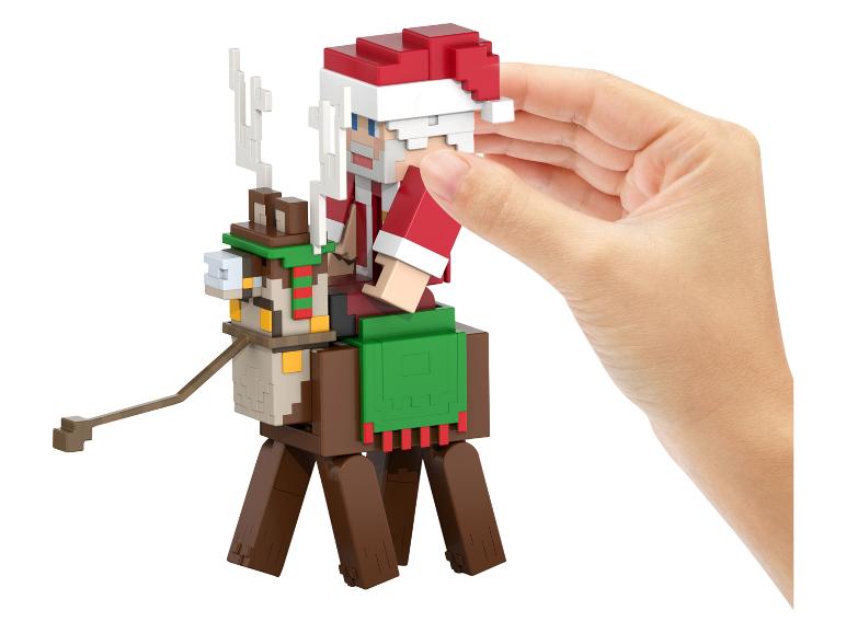 Minecraft figurka Santa Clause na sobovi, držená rukou.