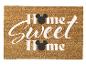 Hnědá rohožka s nápisem „Home Sweet Home“ a černými myšími hlavami.