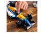 Ruka osoby upravuje modro-žlutý model závodního vozu Lego Williams Formule 1.