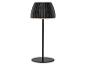 Černá stolní lampa s plisovaným stínidlem a kulatou základnou, osvětlená.