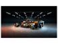 Model závodního vozu Lego McLaren Formule 1 v tmavé garáži s jasnými světly.