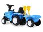 Modrý dětský traktor New Holland s přívěsem a lopatkou.