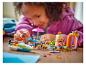 Dívka si hraje se sadou LEGO Friends, s lodí, jídelním koutem a pláží.