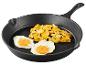 Smažená vejce a brambory na litinové pánvi.