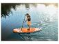 Muž na paddleboardu na jezeře, užívající si slunečné počasí