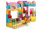 Lego figurka v barevném obchodě se sladkostmi s drapákem a cukrovinkami.