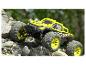 Žluto-černý monster truck Extron šplhá po skalách.
