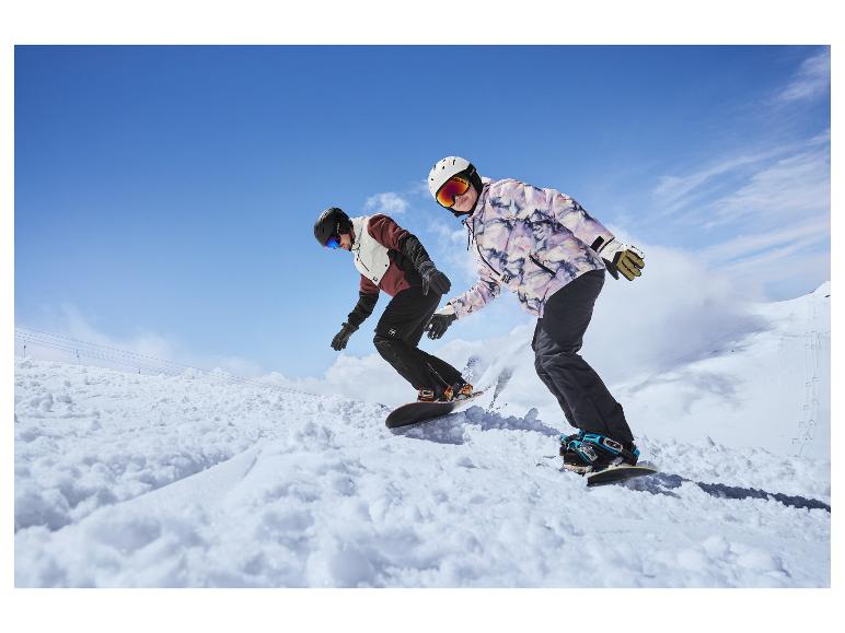 Dva snowboardisté sjíždějí zasněžený svah.