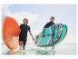 Dvě osoby nesou nafukovací paddleboardy Aqua-Marina ve vodě.