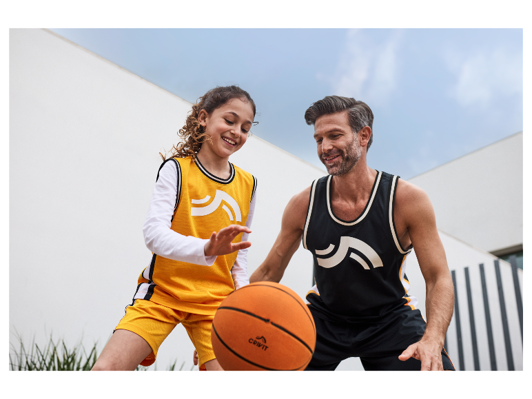 Otec a dcera hrají basketbal s míči Crivit.