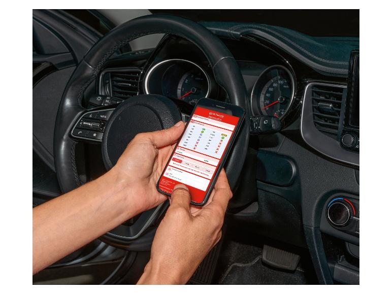Osoba používá smartphone s aplikací ULTIMATE pro diagnostiku automobilu v autě.