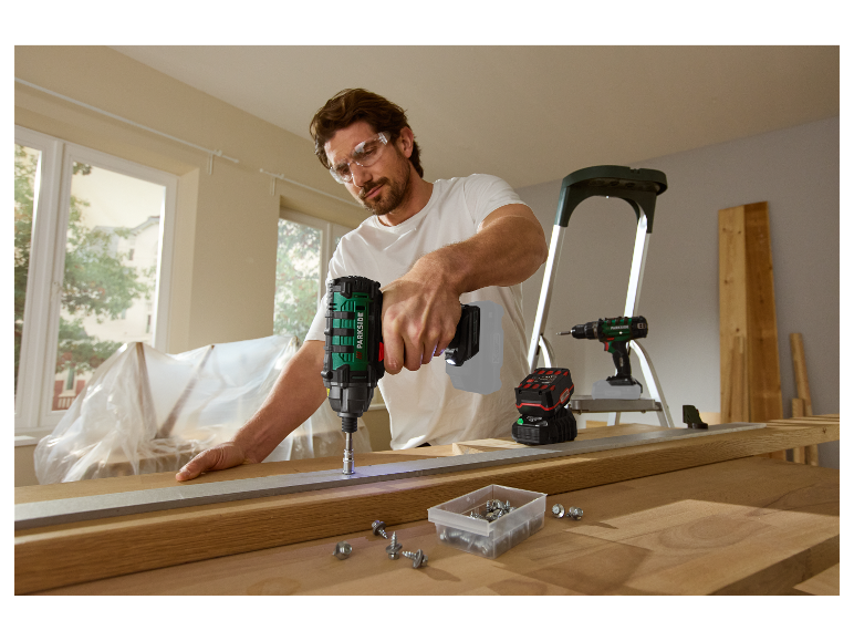 Muž používá akumulátorový šroubovák Parkside na práci se dřevem.