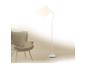 Bílá stojací lampa osvětluje béžové křeslo v minimalistickém interiéru.