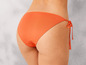 Oranžové bikiny s mašlemi po stranách.