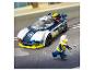 Lego policejní auto a minifigur na silnici v dešti.