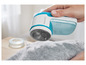 Modrý stroj na odstranění žmolků Philips se používá k odstranění žmolků ze šedého svetru.