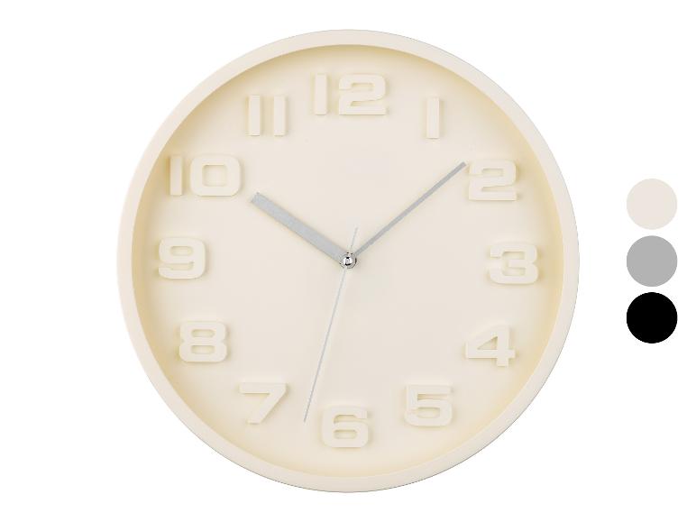 Kulaté nástěnné hodiny, minimalistický design, krémová barva.