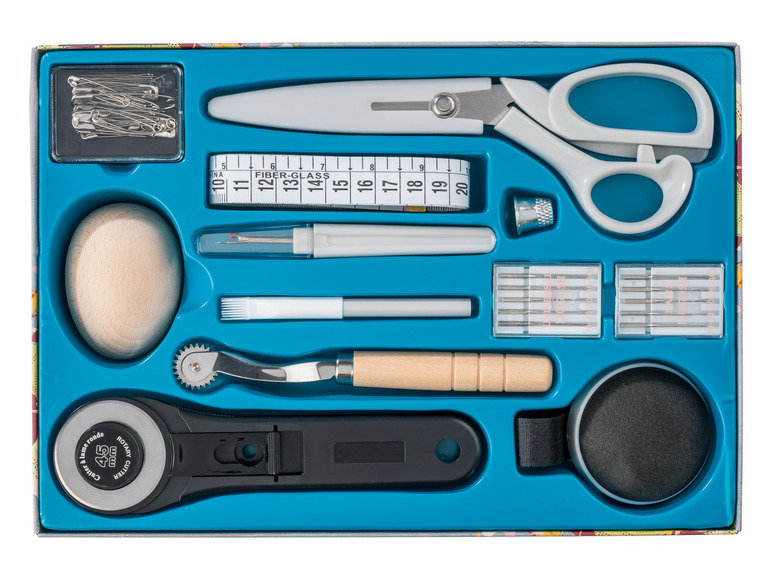 Sada na šití s rotačním nožem, nůžkami, jehlami a měřicím pásmem.