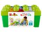 Úložný box LEGO Duplo s barevnými kostkami a hrajícím si dítětem.