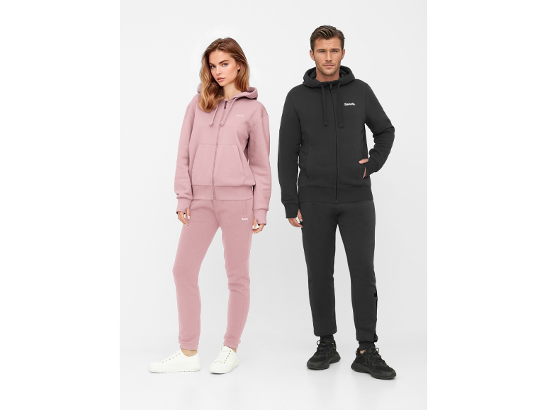 Muž a žena v mikinách na zip a teplácích, žena v růžové, muž v černé.