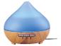 Difuzér esenciálních olejů ve tvaru kapky s dřevěným podstavcem a modrým světlem.