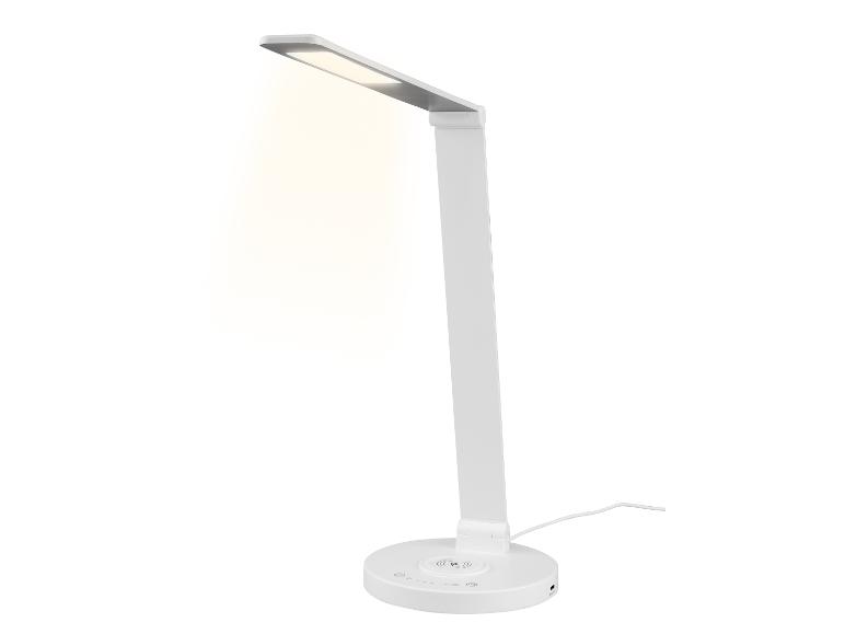 Bílá LED stolní lampa s bezdrátovou nabíječkou.