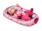 Panenka Baby Born v růžovém pyžamu s dudlíkem, ležící v měkkém, vzorovaném koši.