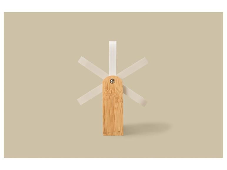 Dřevěný sušák na nádobí s bílými kolíčky na béžovém pozadí