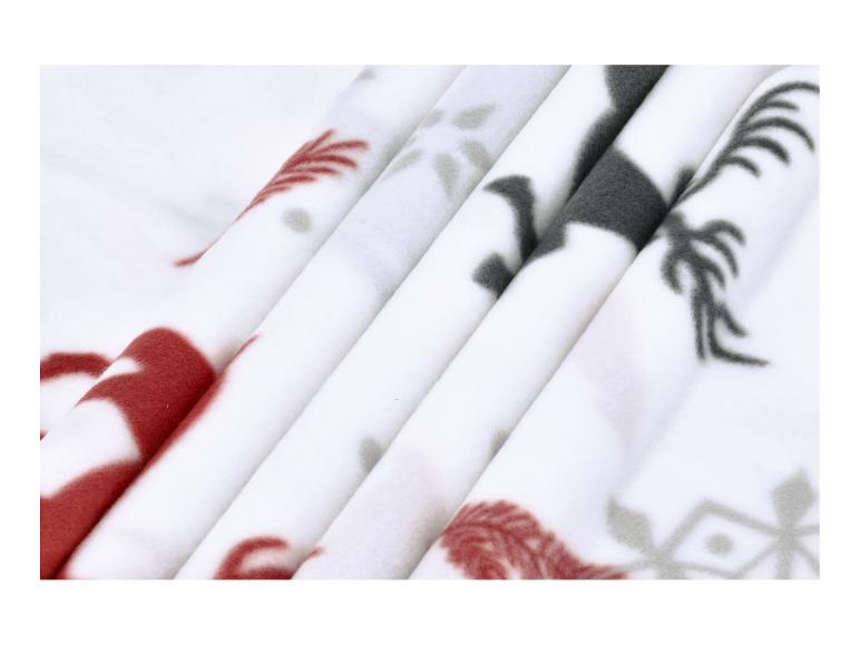 Bílá fleecová deka s červenými a šedými vzory.