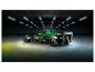 Zelený závodní vůz Aston Martin F1 v tmavé garáži s neonovými světly.