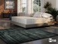 Dvojlůžko se šedým kobercem a logem Hns sleeping system.