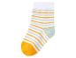 Pár bílých ponožek se žlutými a světle zelenými pruhy.
