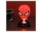 Červeně osvětlená noční lampa Spiderman na černé základně, s rozmazaným fotoaparátem v pozadí.