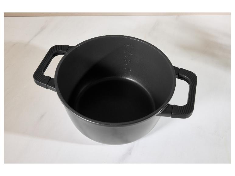 Černý hrnec s uchy a měrnými značkami na bílém povrchu