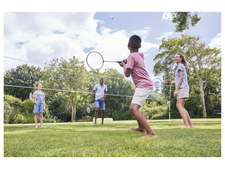 Rodina hraje badminton na zahradě.